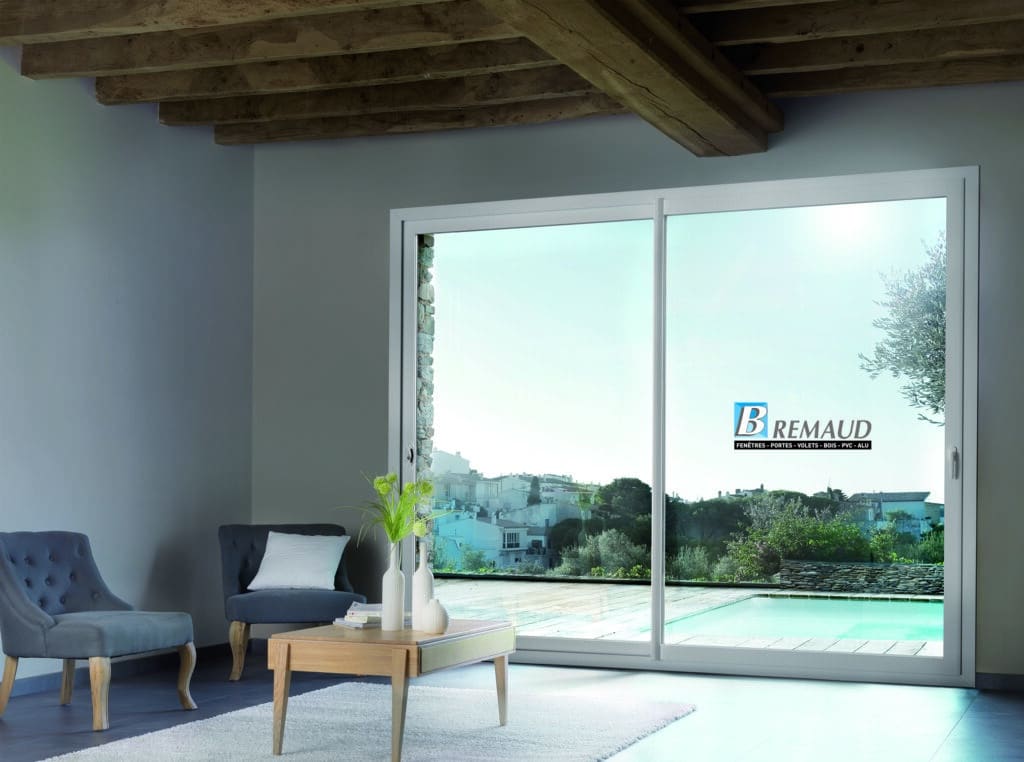 Baie Vitrée Coulissante Brémaud : Design et Lumière Baie vitrée coulissante Brémaud offrant une vue panoramique sur piscine et village. Salon moderne lumineux.