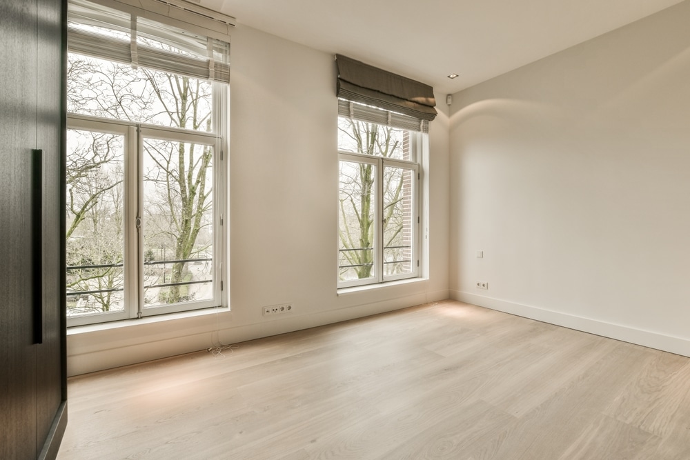 An,Empty,Room,With,Wood,Flooring,And,Large,Windows,Looking